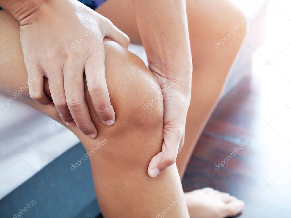 Close-up of Asian women with knee and leg pain By using hands to massage body to relieve pain