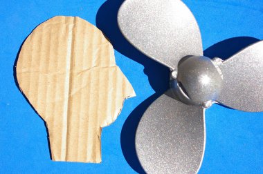 Silüeti stilize edilmiş bir adamın kafası gümüş bir pervanenin yanında. Zihinsel sağlık sorunları konsepti, psikoloji araştırması ve insan beyni araştırması.