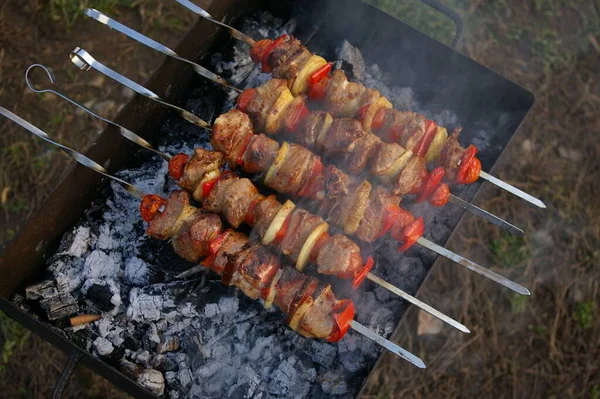Espetos de porco suculentos marinados grelhados ao ar livre com fumaça. Cozinhar espetos concurso com bacon, lombo de porco desossado e legumes em chamas. — Fotografia de Stock