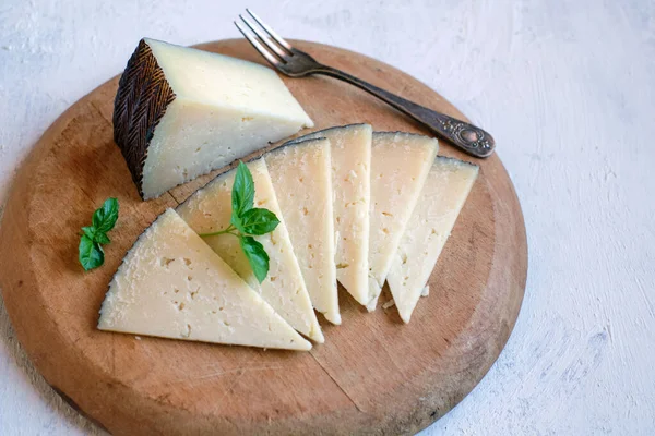 İspanyol Manchego 'sunun porsiyonları kesme tahtasındaki peyniri iyileştirdi