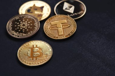 Şifreleme para birimi Bitcoin vurgulanan, siyah arkaplan ile çeşitli altın kripto para birimleri.