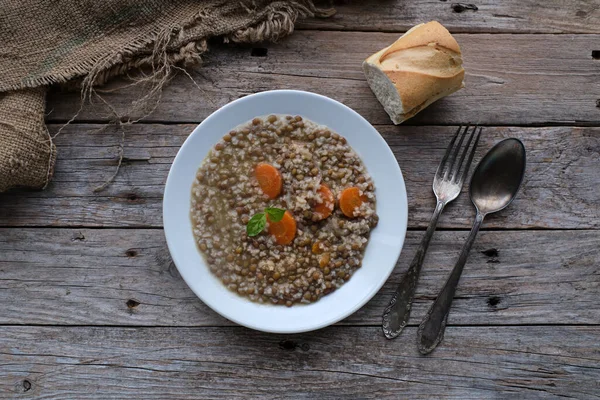 Kırsal ahşap masada havuçlu ve pirinçli mercimek tabağı. Üst görünüm