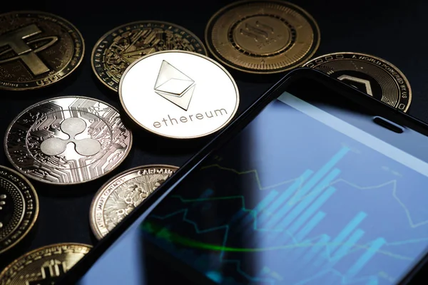 Ethereum sikkeyi akıllı telefon ve diğer altın kripto para birimleriyle birlikte yakın plan çek.