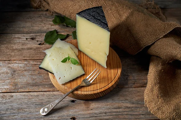ボード上のスペインの半硬化チーズの一部 ストック画像