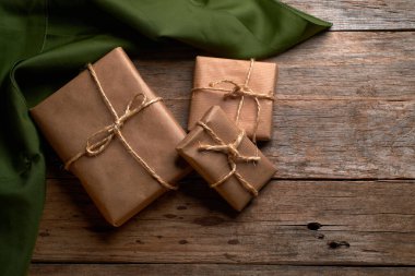 Kahverengi kraft kağıdına sarılı kutular ve kırsal ahşap masa üzerinde iple bağlanmış.