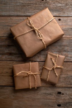 Kahverengi kraft kağıdına sarılı kutular ve kırsal ahşap masa üzerinde iple bağlanmış.