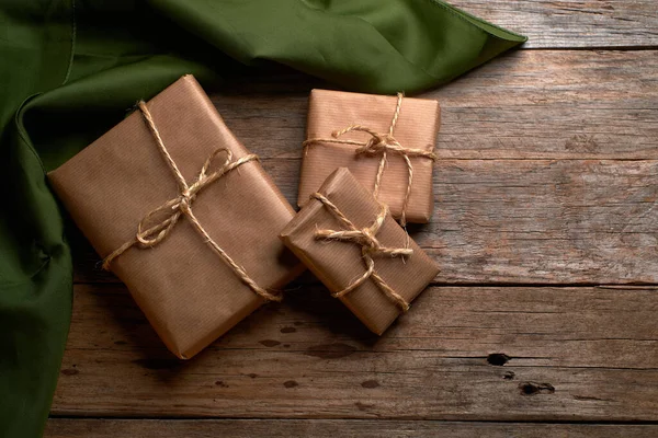 Kahverengi kraft kağıdına sarılı kutular ve kırsal ahşap masa üzerinde iple bağlanmış.