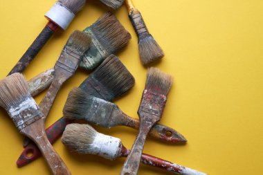Sarı arkaplan ve kopyalama alanı üzerinde birkaç eski ve çok kullanılmış fırça