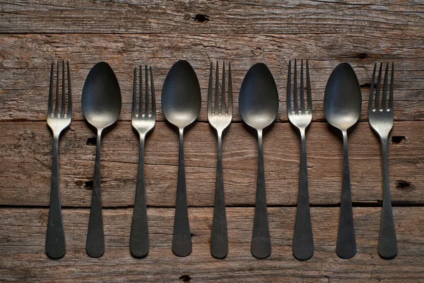 Köy tahtasında eski kaşıkların ve çatalların arka planı