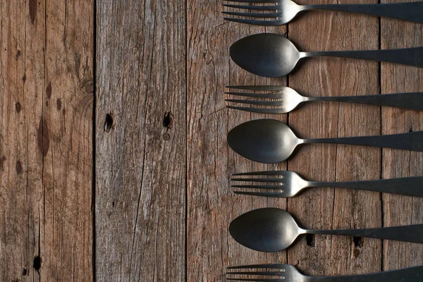 Köy tahtasında eski kaşıkların ve çatalların arka planı