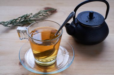 Kırsal ahşap masada cam bardakta yeşil çay.