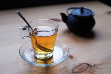 Kırsal ahşap masada cam bardakta yeşil çay.