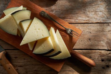 Tahta bir tahtanın üzerinde İspanya 'dan alınmış yarı pişmiş peynirin yakın çekimi.