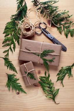 Kraft kağıdına sarılı Noel paketleri sade ahşap kaplamalı jüt ile bağlanmış.