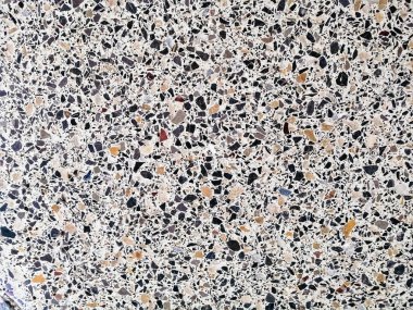 Siyah-beyaz küçük kaotik kapsamalar şeklinde mermer parçalı arka plan fayansları.