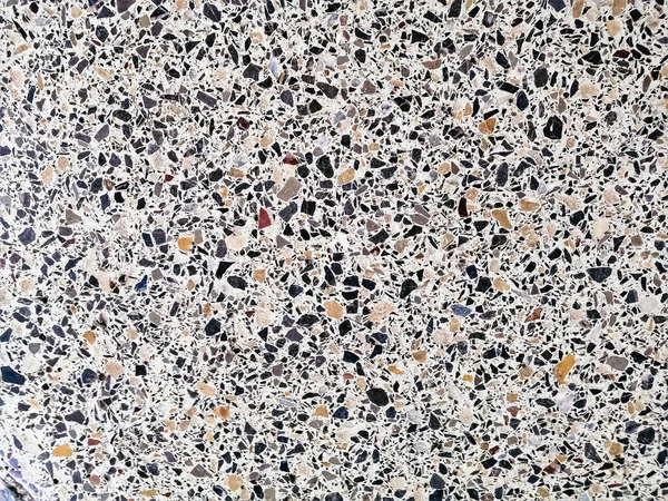 Siyah-beyaz küçük kaotik kapsamalar şeklinde mermer parçalı arka plan fayansları.