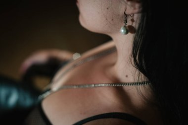 El yapımı küpelerin sol tarafındaki yakın plan. Kadın kulaklarında eski mücevherler