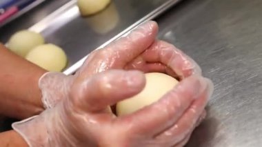 Pasta şefi elleriyle hamburgerden bir çörek yapıyor. El işi.