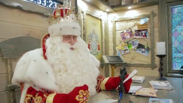 Rosyjski Święty Mikołaj siedzi przy stole w swoim domu. Miasto Wielkiego Żelaza. — Wideo stockowe