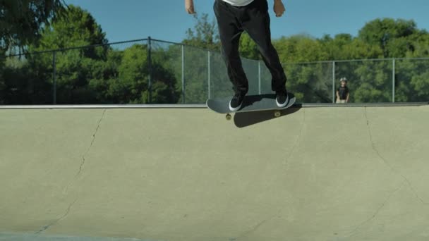 Opleiding van skateboarders. Spring op een skateboard in de lucht. Balanceren skateboarder tijdens een skateboard stunt. Een man voert complexe oefeningen uit op een skateboard. — Stockvideo