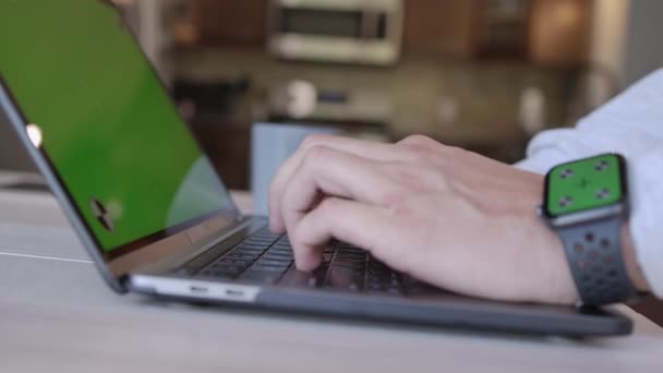 Un hombre trabajando en un portátil con una pantalla verde desde casa. Computadora con una llave de cromakey Spb para propósitos comerciales con una llave de cromakey. La pantalla verde en el — Vídeo de stock