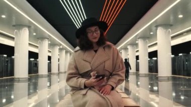 Kız metroda trenini bekliyor ve telefonundan mesaj atıyor. Boş bir metro. Karantina sırasında Metro.