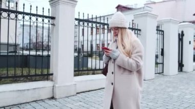 Beyaz şapkalı, güzel ceketli, üniversitede sosyal medyaya ve etkinliklere ayak uydurmak için akıllı telefonuyla haber akışı sağlayan modaya uygun bir öğrenci. Şey...