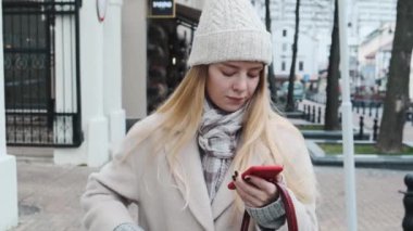 Beyaz şapkalı, güzel ceketli, kablosuz kulaklıkla müzik dinleyen modaya uygun bir öğrenci. Kız çantasından kulaklıkları çıkardı..