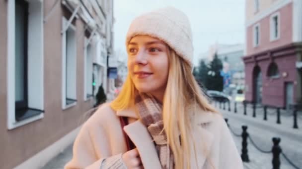 Primer plano de una joven rubia paseando por la ciudad en cámara lenta, durante la temporada navideña. — Vídeos de Stock