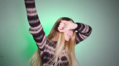 Kamerada dans eden parlak görünüşlü bir kız. Duygular kamerada. Kız mutluluktan dans ediyor..