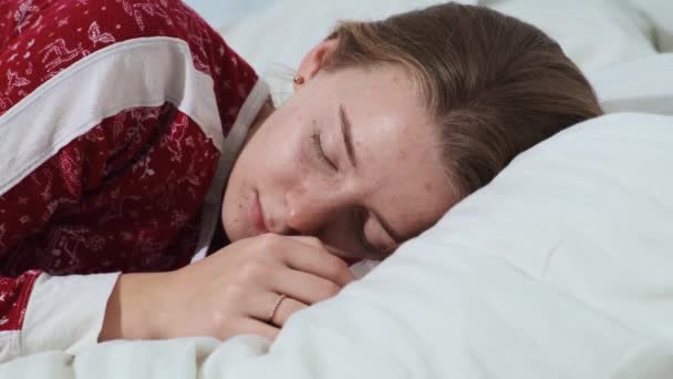 Seorang gadis muda yang tenang tidur nyenyak di tempat tidur, nyaman segar di atas bantal lembut, menikmati suara tidur yang sehat di pagi hari — Stok Video
