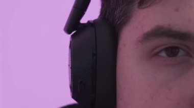 Bilgisayarının başında oturan ve çalışan büyük kulaklık takan bir adamın yakın çekimi.. 