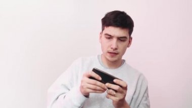 Cep telefonuyla arka planda gezici oyunlar oynayan bir adam. Telefonuyla yarış oyunları oynayan bir adam..