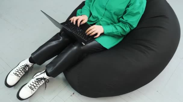 Μια κοπέλα με ανοιχτό πράσινο πουκάμισο δουλεύει στο γραφείο με το λάπτοπ της. Ομαλή διαφάνεια για το κορίτσι. — Αρχείο Βίντεο