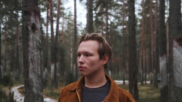 Ein junger blonder Mann schlendert durch den Winterwald. Ein Waldspaziergang an der frischen Luft. — Stockvideo