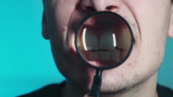 Teeth through a magnifying glass. Teeth through a magnifying glass on a blue background. High quality 4k video — Stock Video