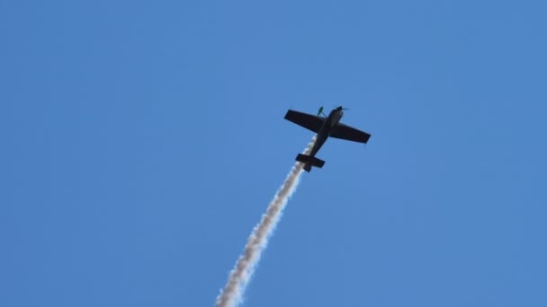 Vliegende display in de lucht met rook door een acrobatisch vliegtuig — Stockvideo