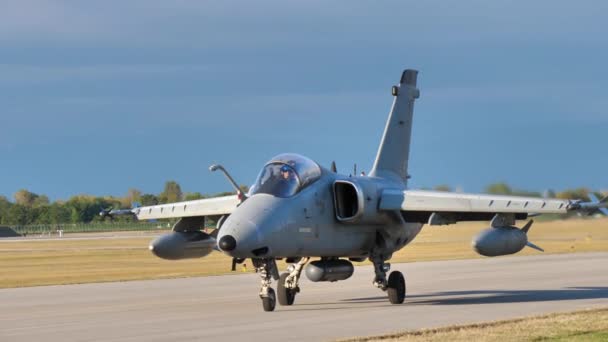 AMX jet repülőgép lassan mozog a kifutópályán a pilóta integetett — Stock videók