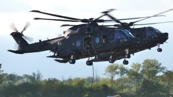 Due elicotteri si librano mentre i soldati scivolano giù sulla corda — Video Stock