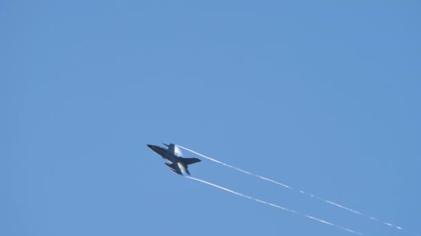 Супер быстрый военный самолет поднимается в небо с конденсационными тропами на крыльях — стоковое видео
