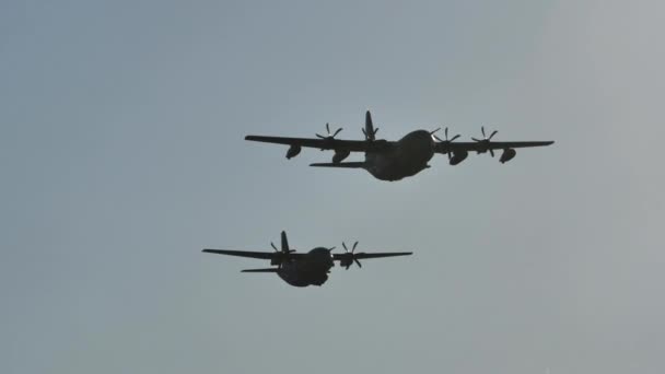 Zwei militärische Fracht-Turboprop-Flugzeuge fliegen parallel am blauen Himmel — Stockvideo