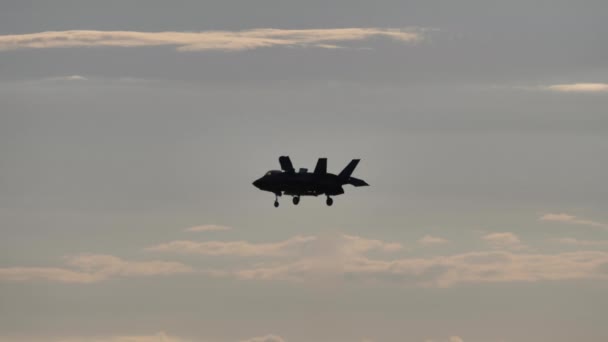 Wojskowy myśliwiec F-35B unosi się nad zachodem słońca niczym helikopter — Wideo stockowe