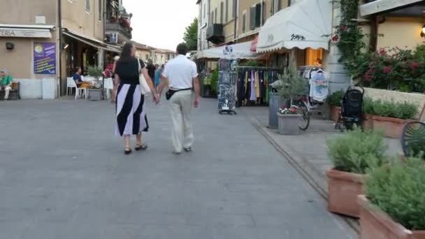 Homme et femme marchent en se tenant la main au centre d'une ville médiévale italienne — Video