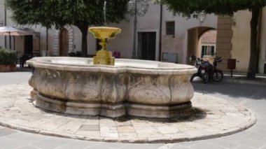 Beyaz mermer bir fıskiyenin tam ortasında bir fıskiye var.