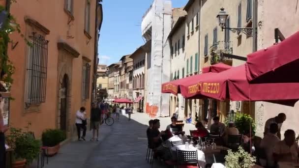 Turistas comem nos restaurantes ao longo das ruas da cidade velha de Volterra — Vídeo de Stock