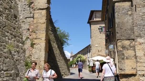 在托斯卡纳沃尔特拉中世纪城墙的一个拱门下行走 — 图库视频影像