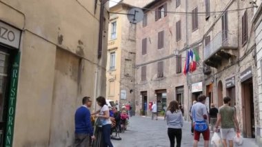 Siena 'da şehir merkezinde rahatça yürüyen insanların olduğu şehir manzarası.