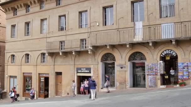 Gevels van historische gebouwen in het centrum van Siena met winkels en toeristen — Stockvideo