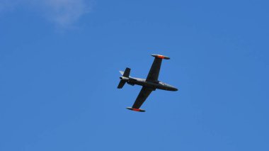 Mavi gökyüzünde uçan bir jet uçağı.