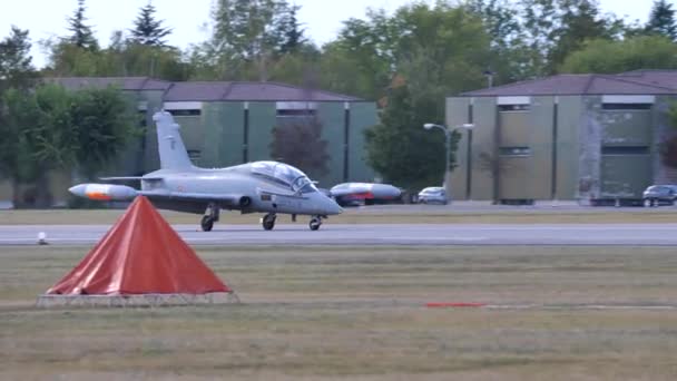 Graues leichtes Militärflugzeug landet an einem sonnigen Tag — Stockvideo